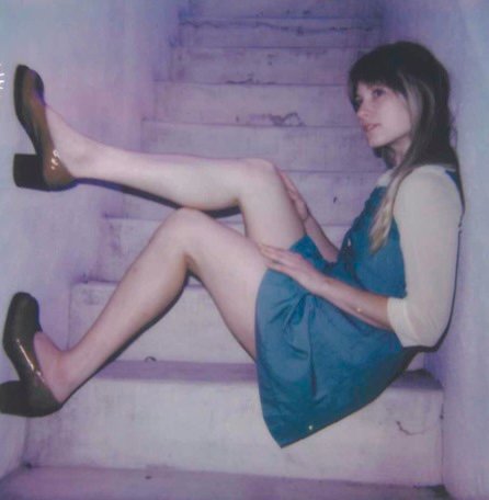 Photo of Kate Bollinger sitting sideways on a staircase